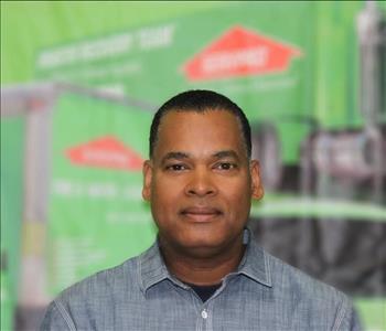 a man in a collared shirt in front of a green background