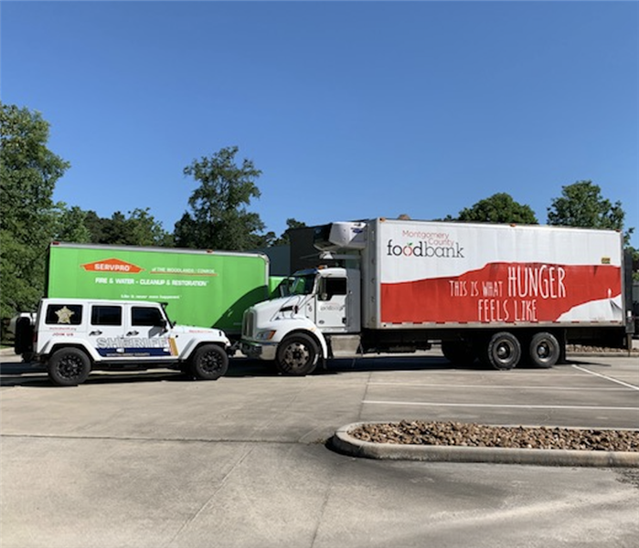 a green SERVPRO truck and a white jeep