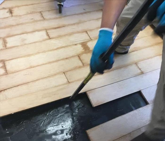 Tech removing water damaged wood flooring.