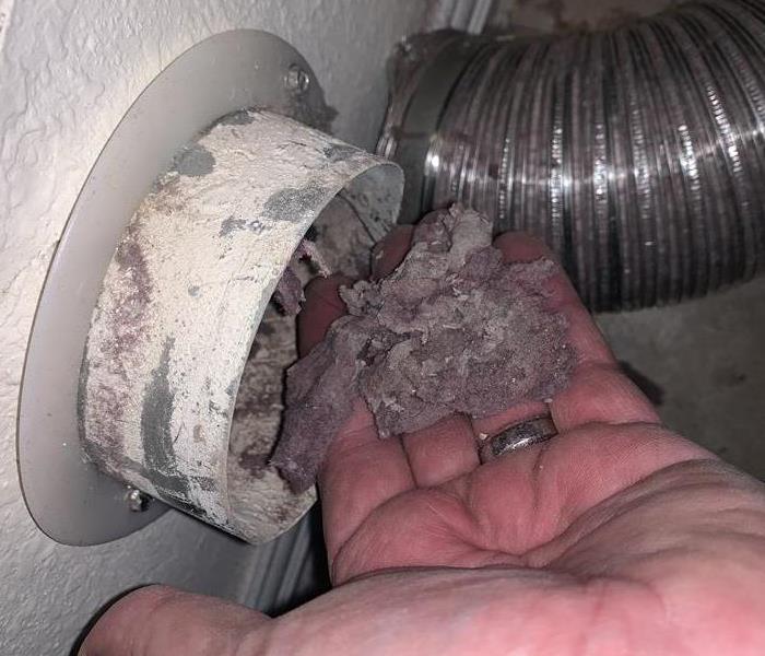 an exposed dryer vent with lint coming out