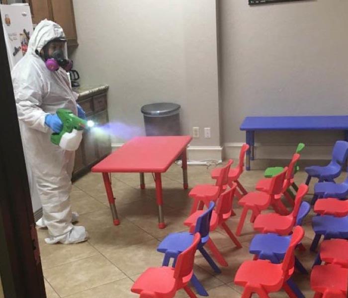 Worker disinfects empty classroom or daycare
